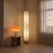 Two lit Muto Space lamps in a warm plaster room with sheer curtains and a white oak floor