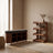 A shoe storage bench and rack in a calm entryway with a travertine floor and linen runner