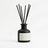 Reed diffuser in a black bottle, white background