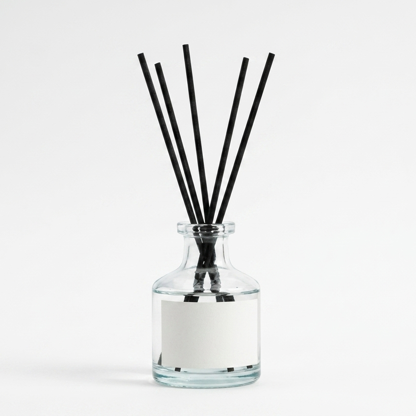 Reed diffuser in a clear glass bottle, white background