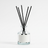 Reed diffuser in a clear glass bottle, white background