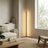 Modern living room with a floor lamp, sofa, coffee table, and large window.