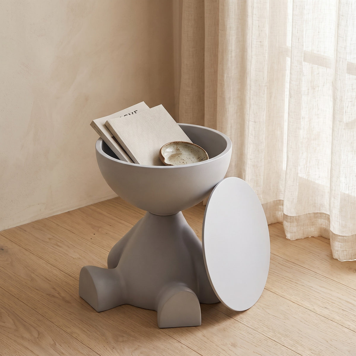 Bowl-top storage end table with its lid removed showing items stored inside