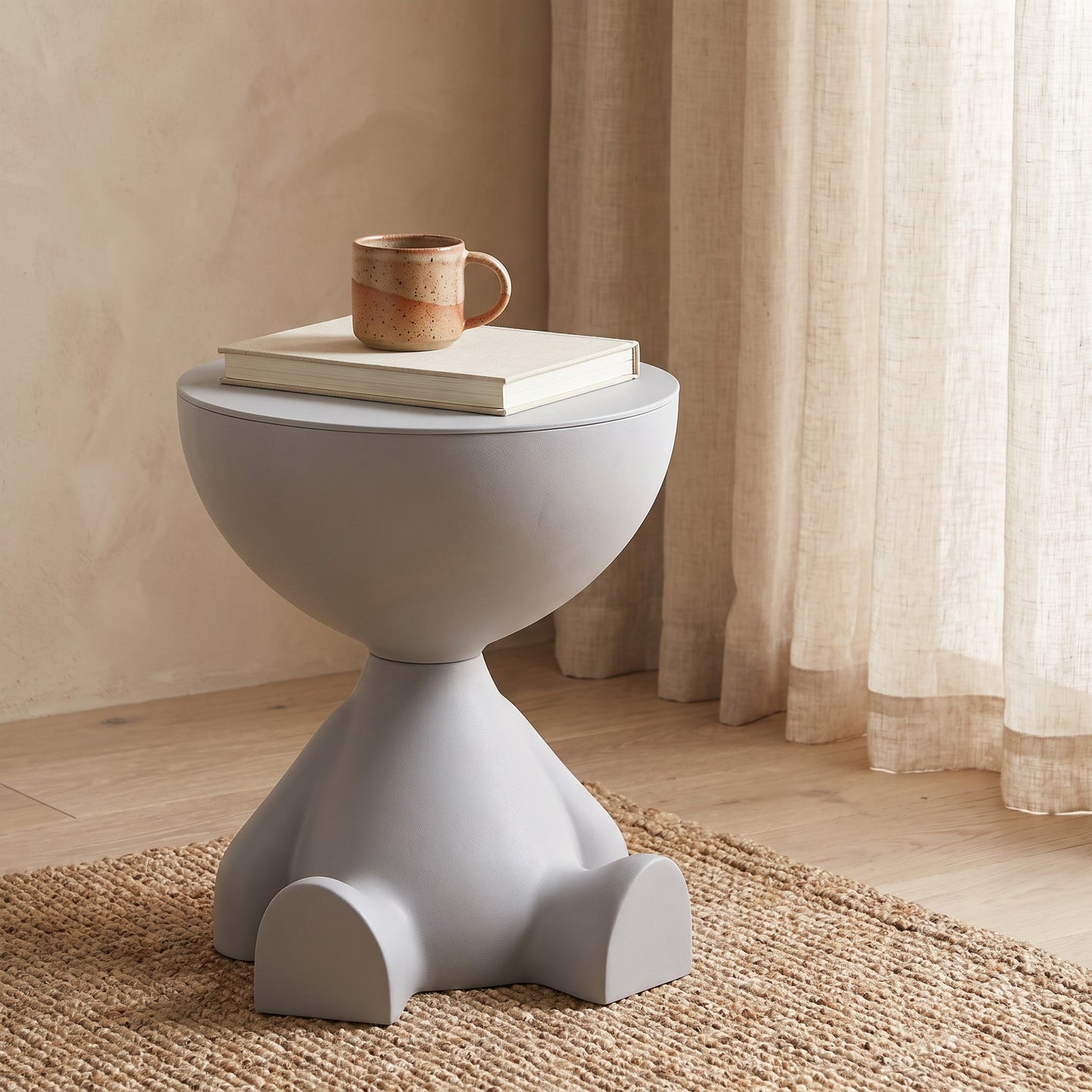 Bowl-top storage end table with a book and mug on top