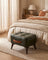 Tufted faux leather ottoman in a warm minimalist room setting