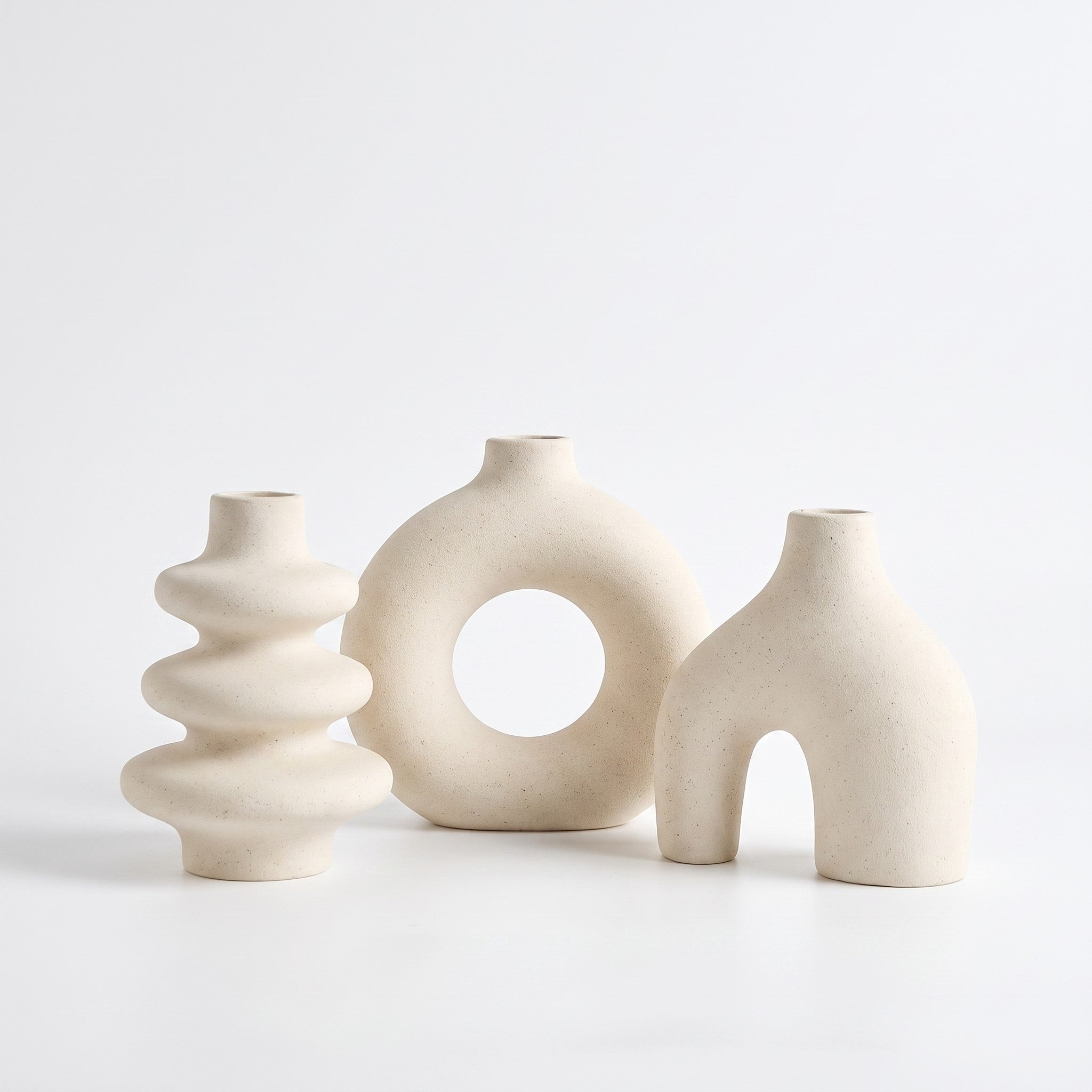 Sculptural ceramic vase in white on white background