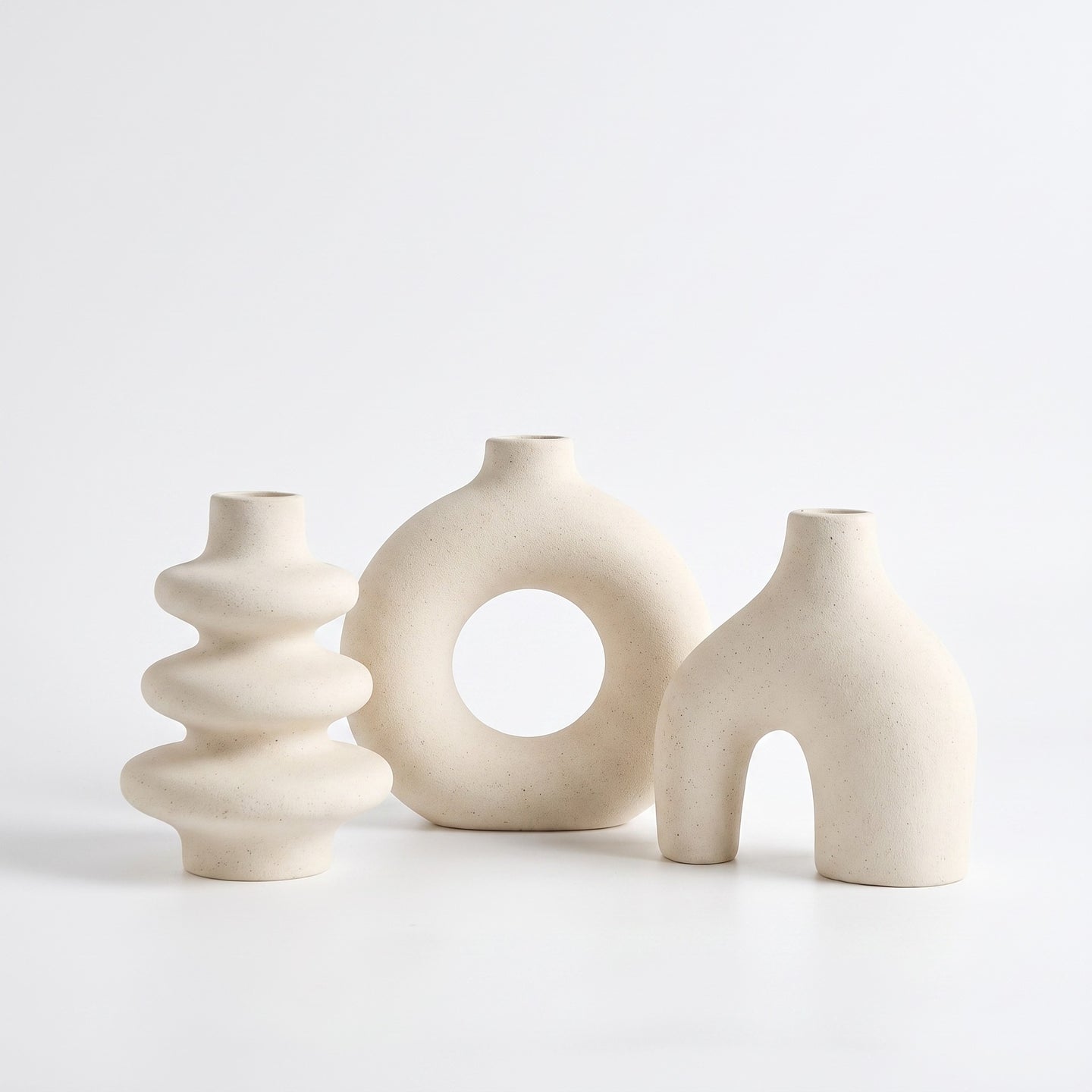 Sculptural ceramic vase in white on white background