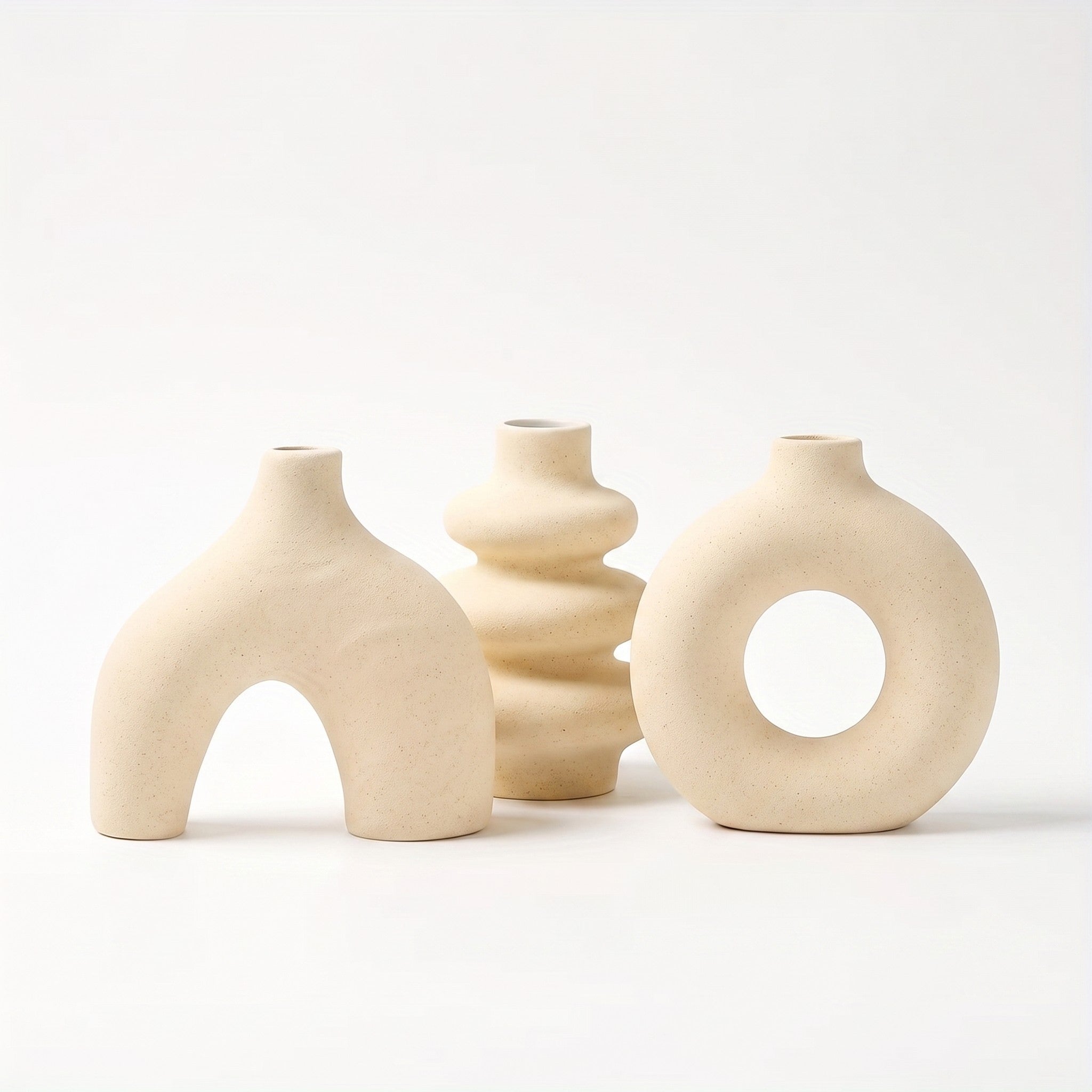 Sculptural ceramic vase in light yellow on white background