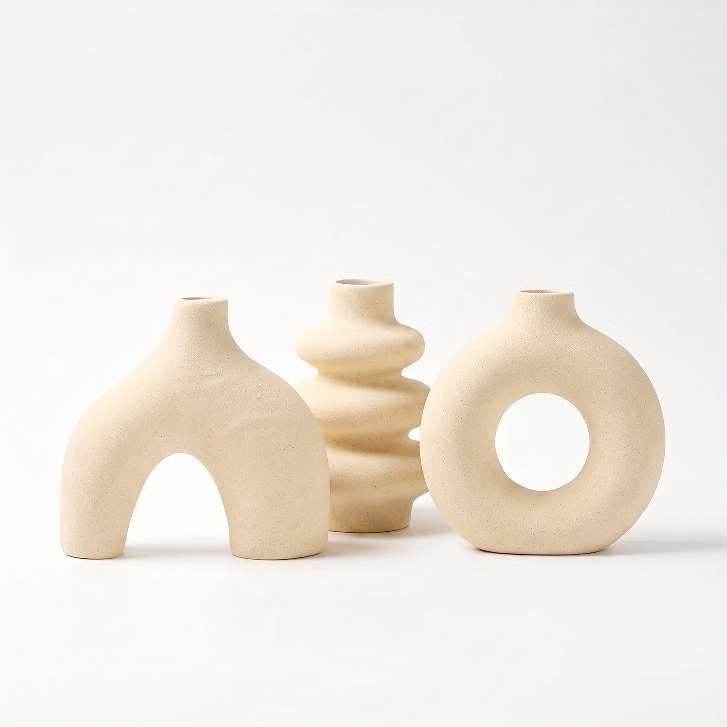 Sculptural ceramic vase in light yellow on white background