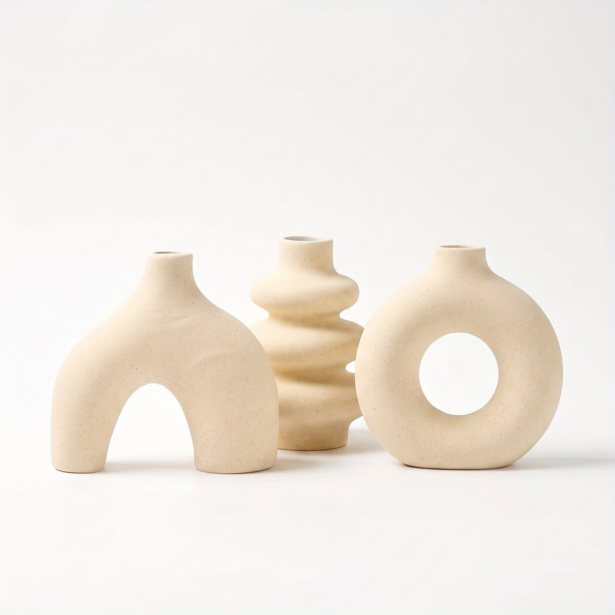 Sculptural ceramic vase in light yellow on white background