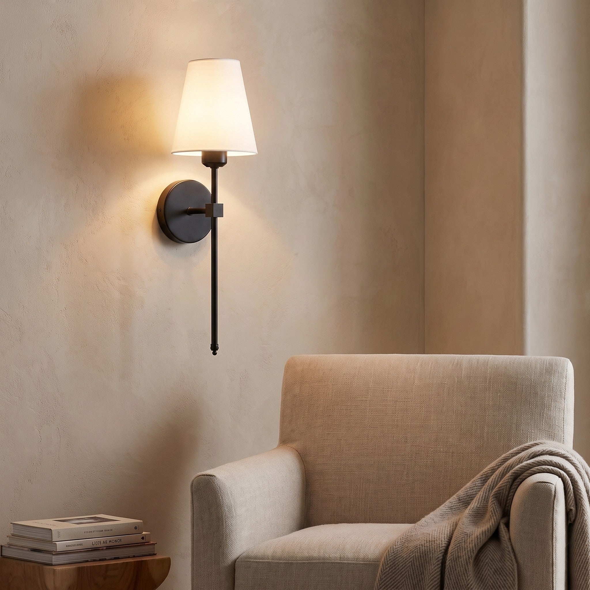 Black cordless fabric shade wall sconce in a reading nook scene