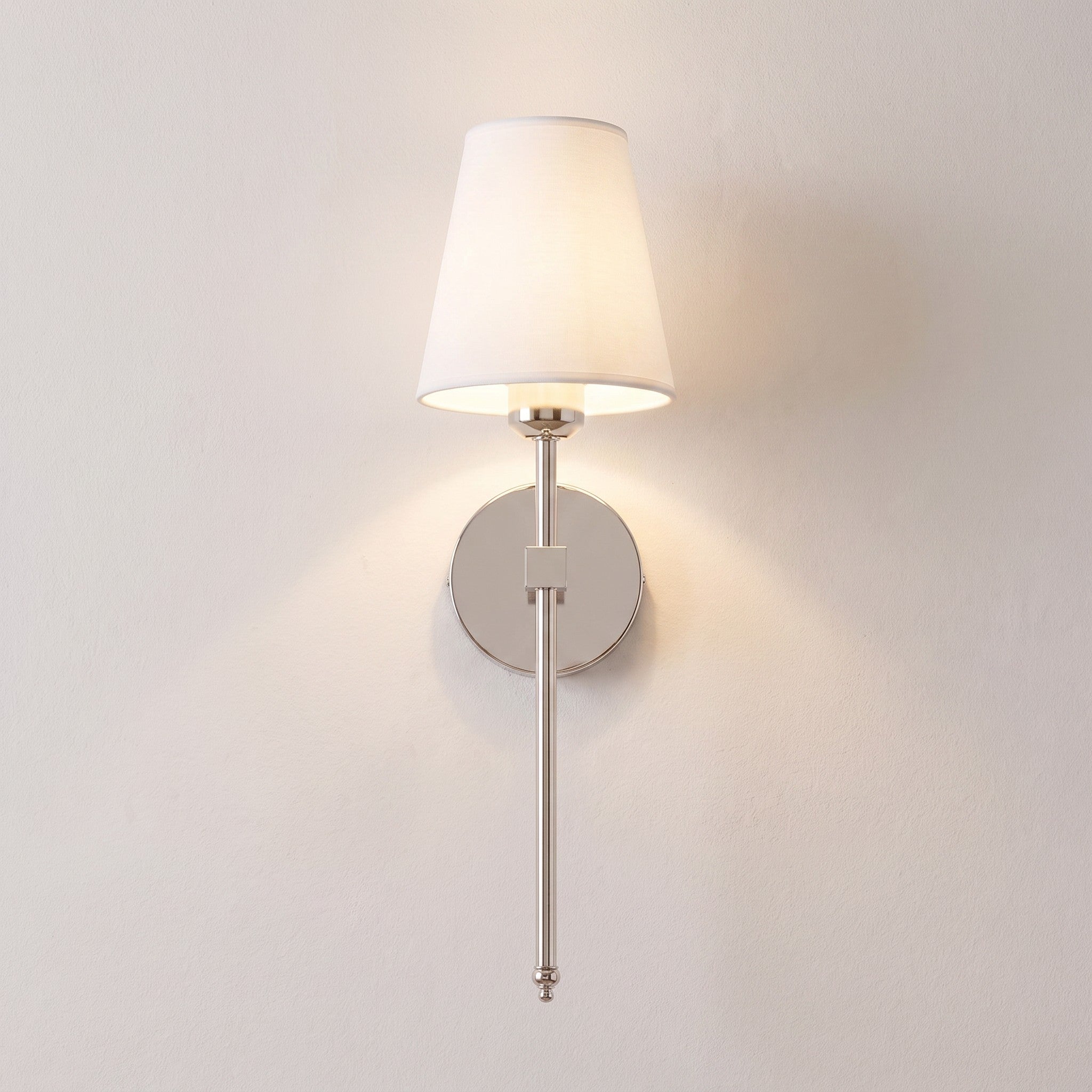Silver cordless fabric shade wall sconce mounted and lit