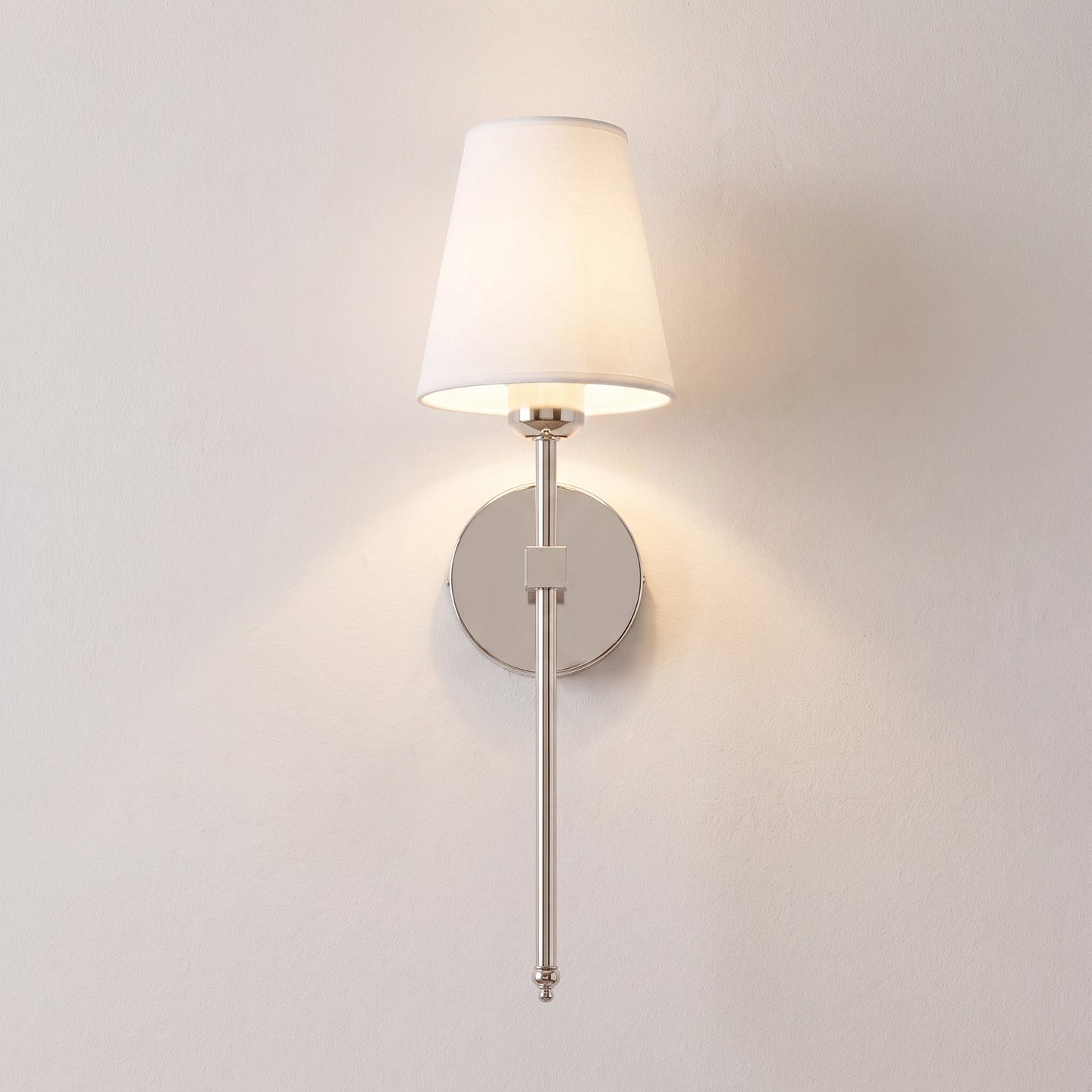 Silver cordless fabric shade wall sconce mounted and lit