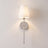 Silver cordless fabric shade wall sconce mounted and lit