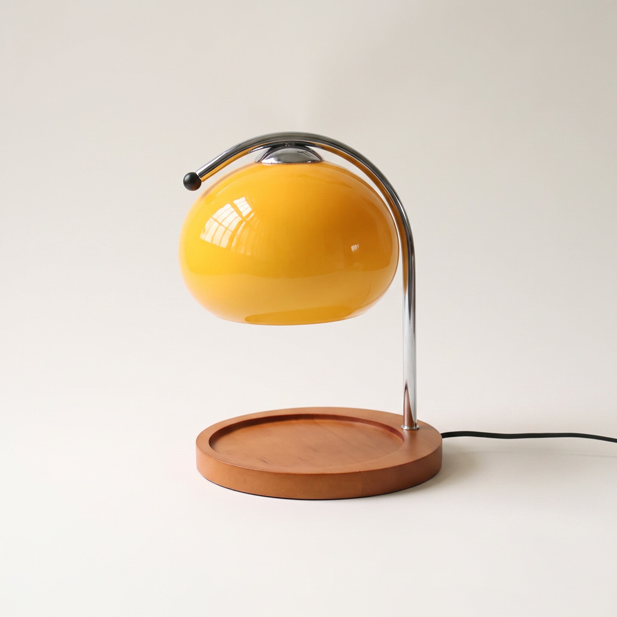 Glass candle warmer lamp in yellow, shown alone with an empty base on a plain off-white background