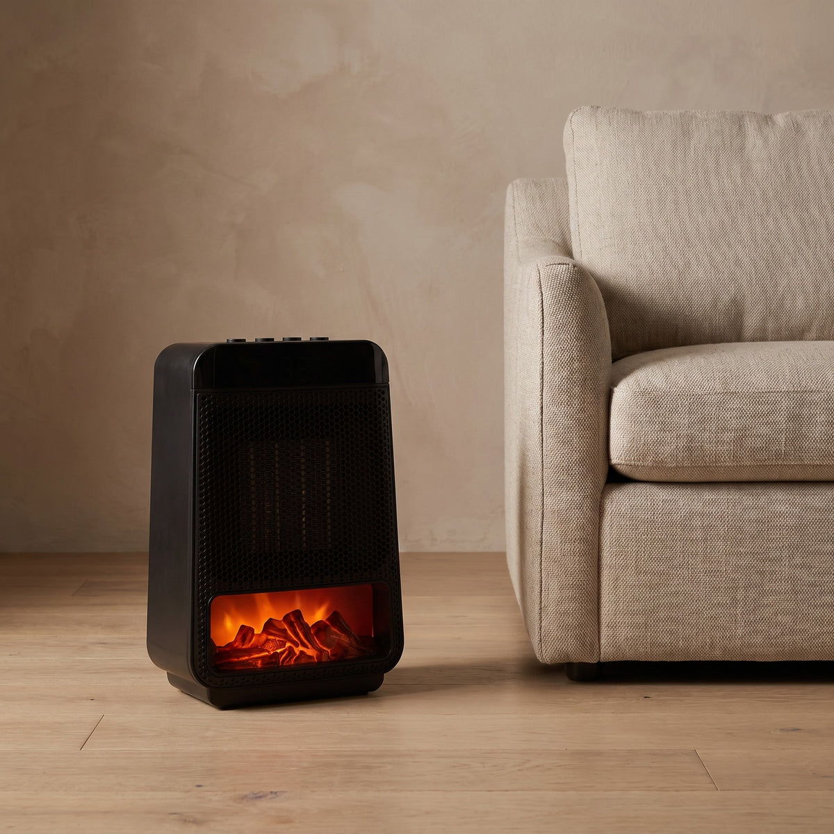 Flame effect ceramic heater running beside a linen armchair on a white oak floor