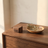 Wood Ring Box closed on a walnut dresser beside a ceramic dish and an olive branch