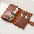 Close-up of the PU Leather Tech Organizer Case in brown, opened flat showing the charger compartment, cable loops, and pen loop