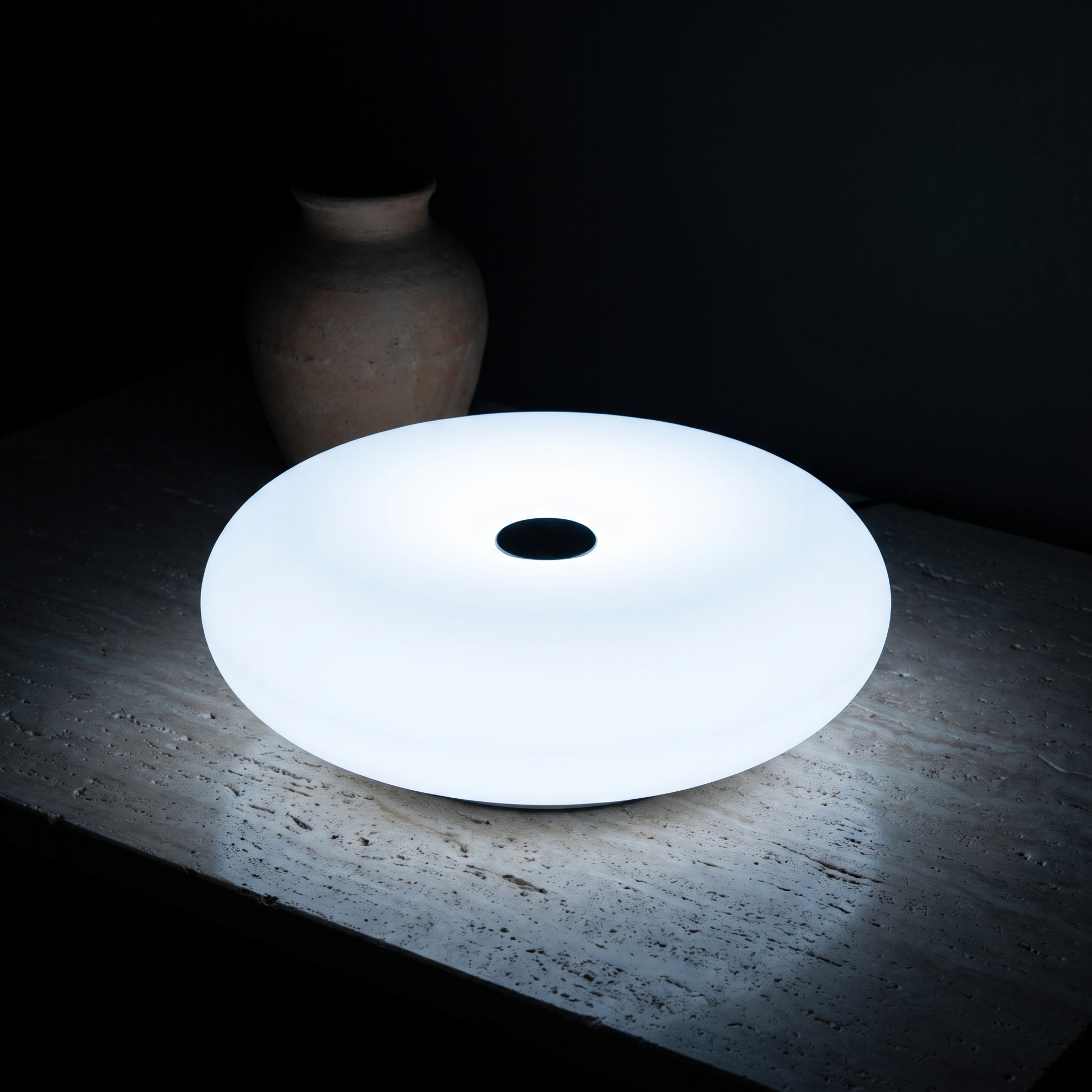 Frosted Donut Table Lamp, White, dark lit scene on travertine