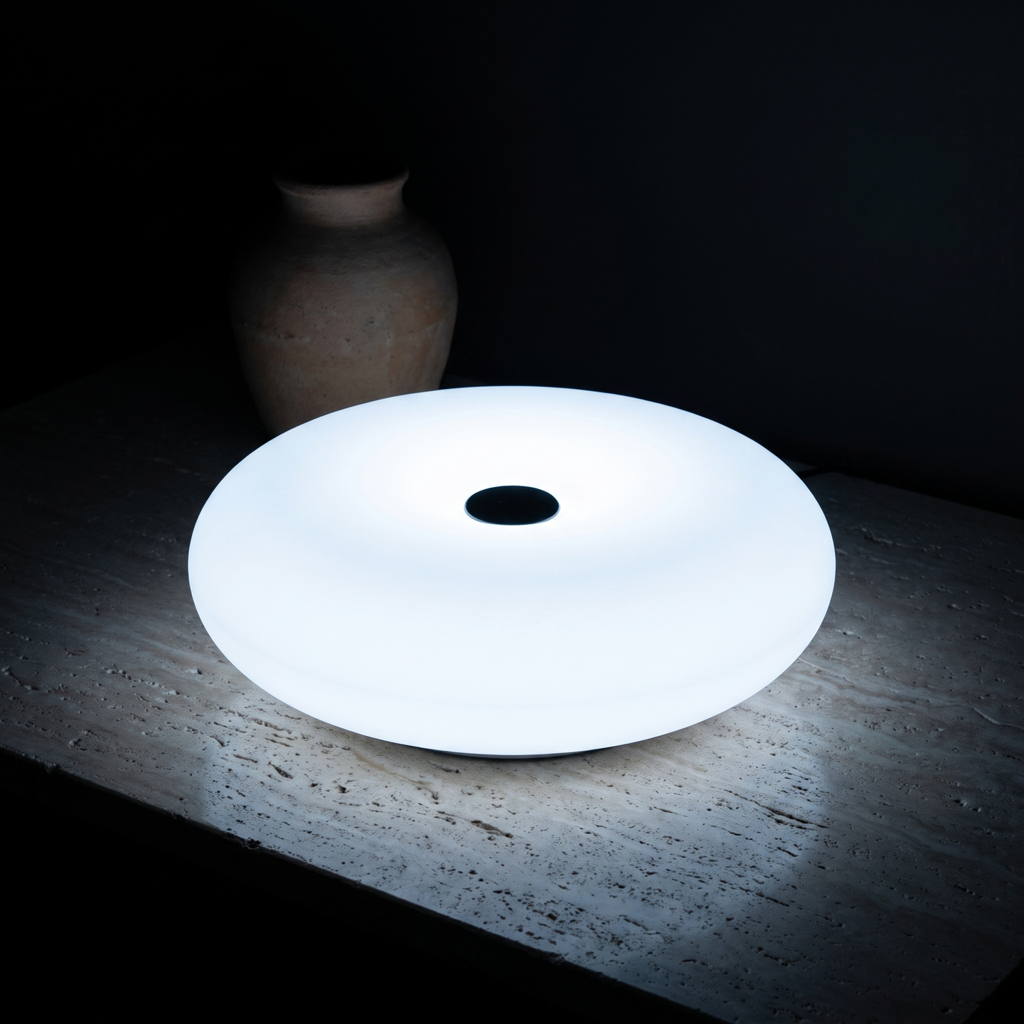 Frosted Donut Table Lamp, White, dark lit scene on travertine