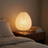 Rice Paper Lantern Table Lamp, lit, on a walnut nightstand