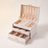 Arched three-layer jewelry box, white finish, lid open showing three sorting layers with rings, earrings, and a necklace