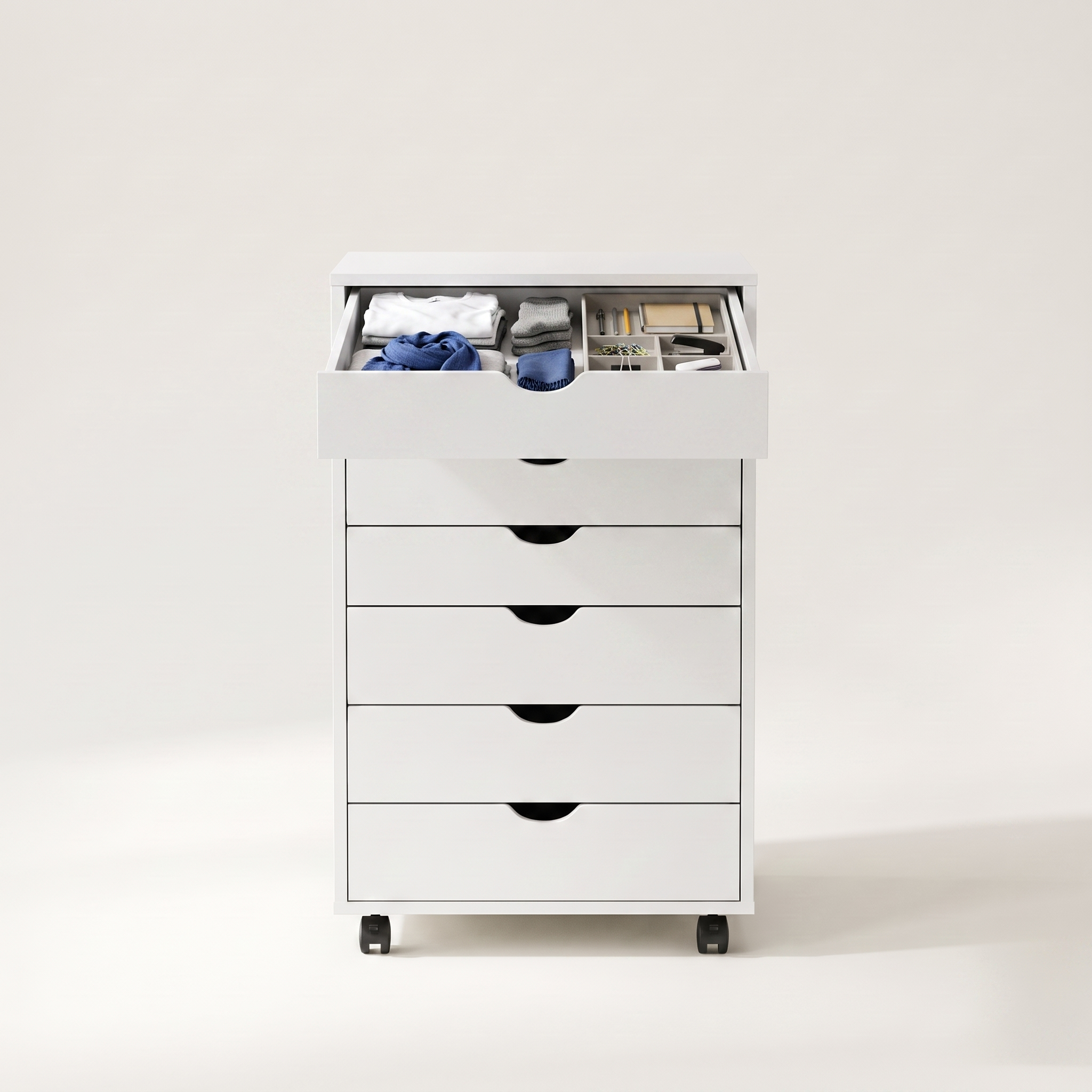 Rolling 7-drawer storage cabinet in white finish, top drawer open showing folded clothing and office supplies inside