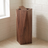Tapered waste bin standing in a tiled bathroom corner, walnut finish