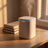 Humidifier running with its mood light glowing on a white oak desk