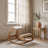Ergonomic Rocking Kneeling Chair standing by a window in a quiet reading corner with a ceramic pot and olive branch.