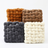 Four woven textured boxes in different colors on a white background