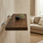 Modern living room with a beige sofa, wooden wall-mounted table, and decorative elements.