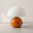 Opal Glass Mushroom Table Lamp on a soft off-white studio background, glossy orange base and opal dome
