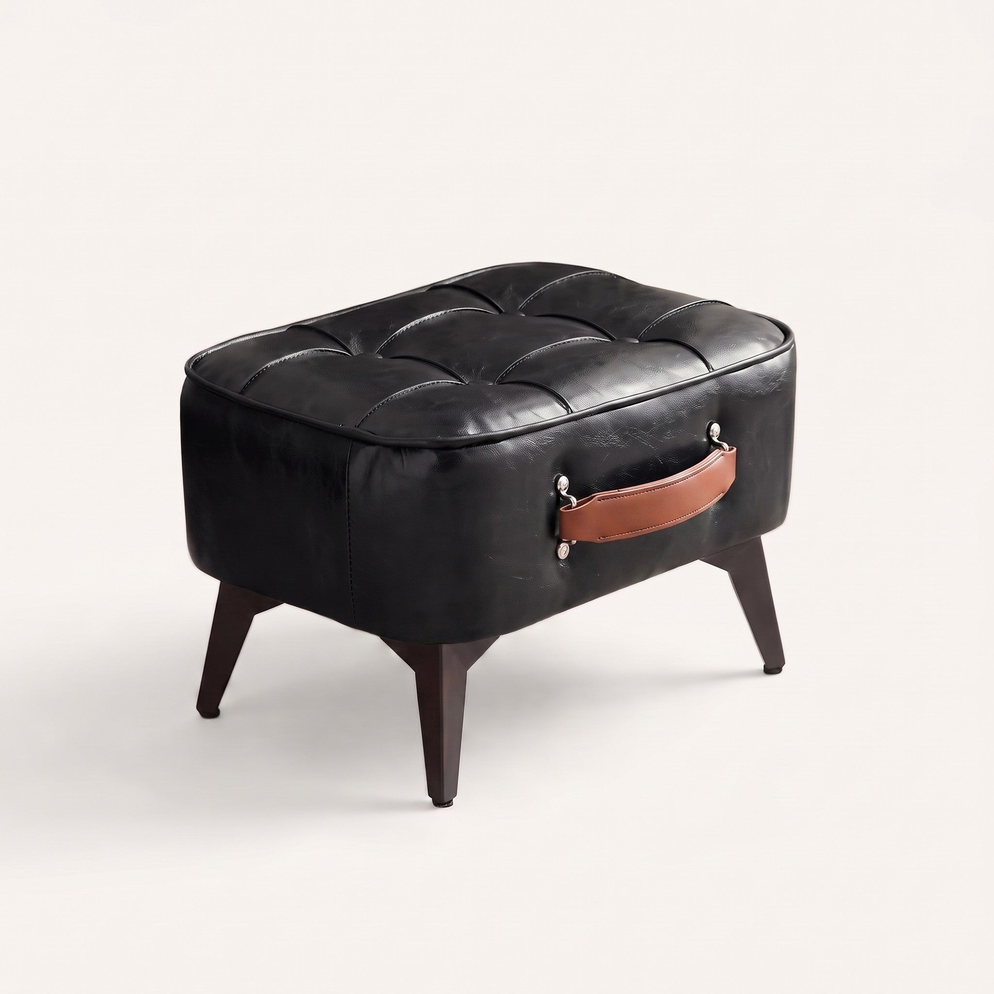 Tufted faux leather ottoman in black, white studio packshot