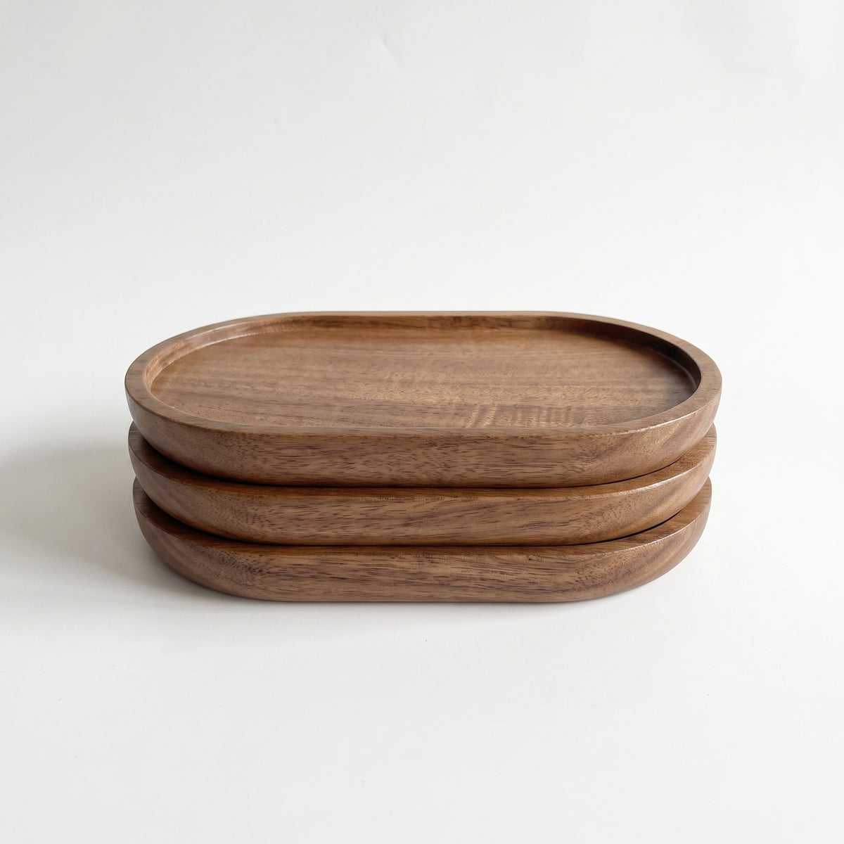 Three-piece oval wood tray set, white background