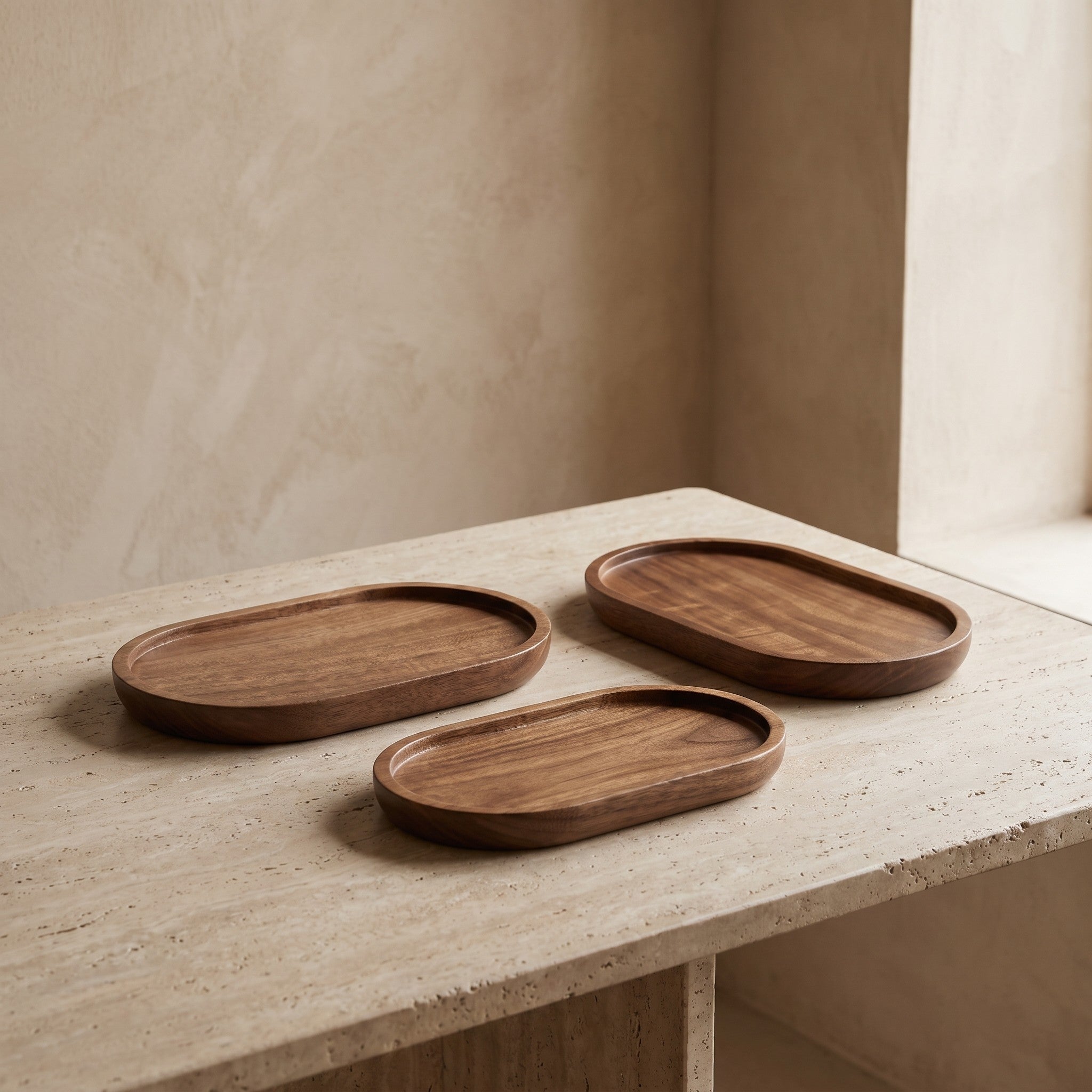Three-piece oval wood tray set styled on a table