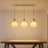 Three-head beige pumpkin pendant light lit above a dining table