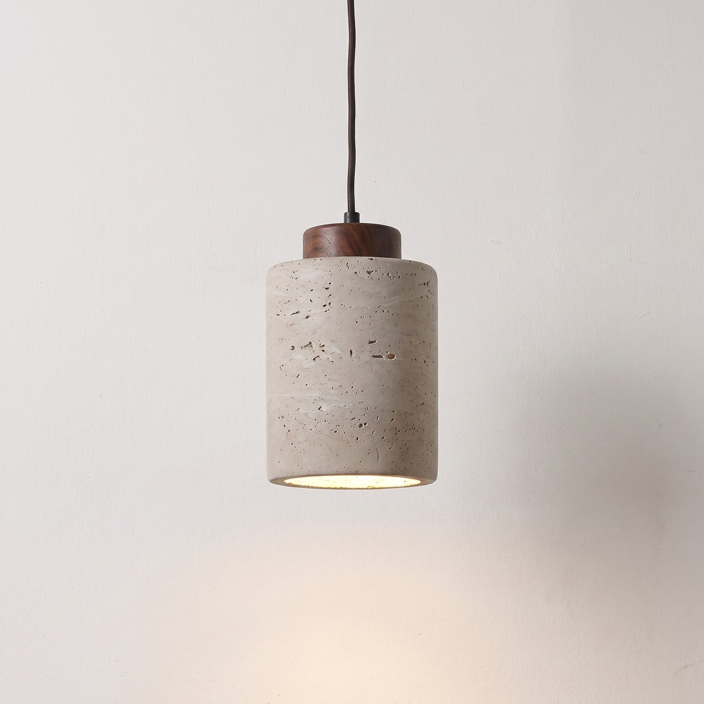 Stone-look pendant, tall shade with a dark wood cap, lit