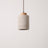Stone-look cylinder pendant with a natural wood cap, studio packshot