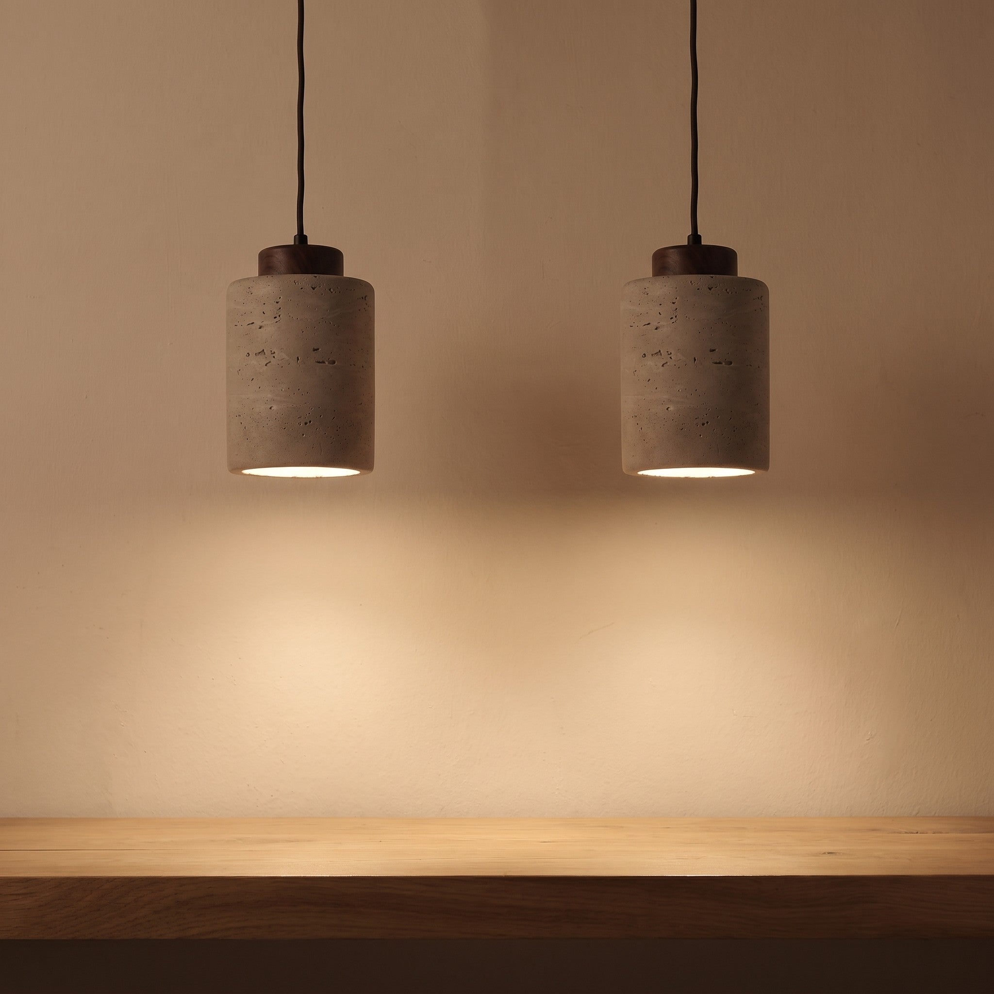 A pair of stone-look pendants lit above a white oak counter