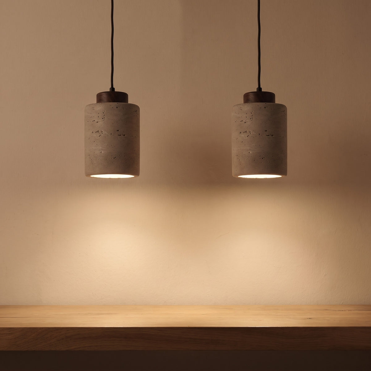 A pair of stone-look pendants lit above a white oak counter
