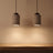 A pair of stone-look pendants lit above a white oak counter