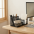 Wooden desk with computer setup including monitor, keyboard, and office supplies.