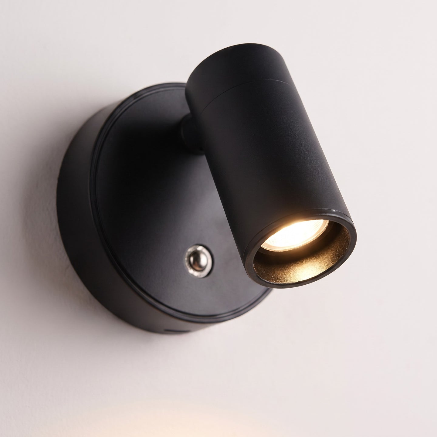 Close detail of the reading light head and its round magnetic wall plate