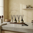 A minimalistic interior setting with diffusers, bowls, and a plant on a shelf.