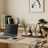 Modern home office with a laptop on a desk, books, and decorative items.