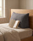 Linen-blend wedge backrest pillow propped against a headboard with a book