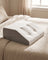 Memory foam leg wedge pillow positioned to support raised legs on a bed