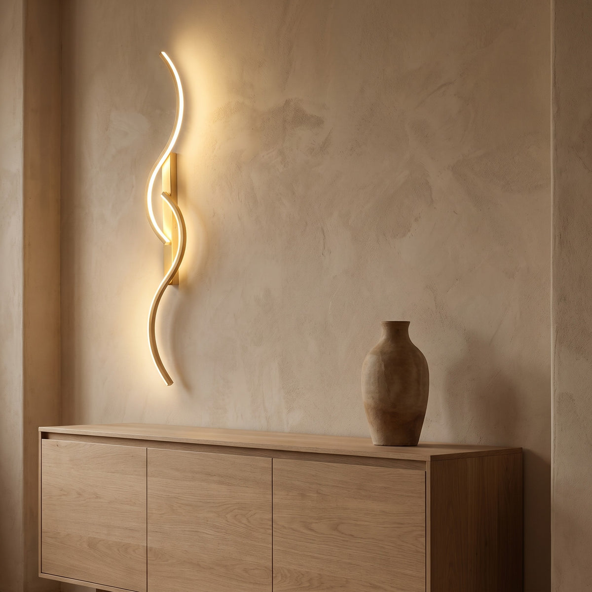 Ribbon curve wall sconce in gold, lit above a white oak sideboard