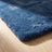 Close detail of the rug edge showing pile depth against a pale oak floor